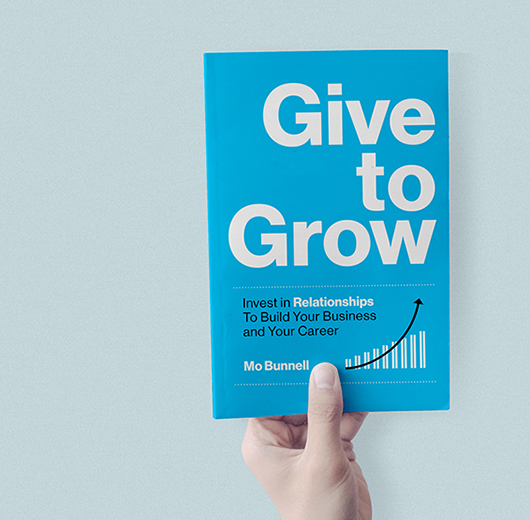 Photo of a paperback copy of Give to Grow in a person's hand