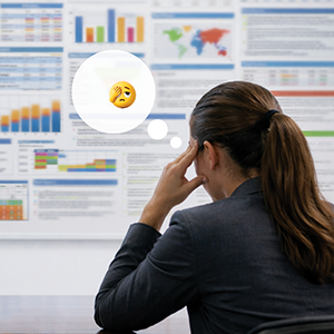 A data analyst looking at a slide projected on a wall that's overcrowded with data, with a facepalm emoji in a thought bubble beside her head.